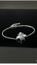 WRAPGAME INDIA silver chain bracelet with a bee charm encrusted with blue and white CZ stones.