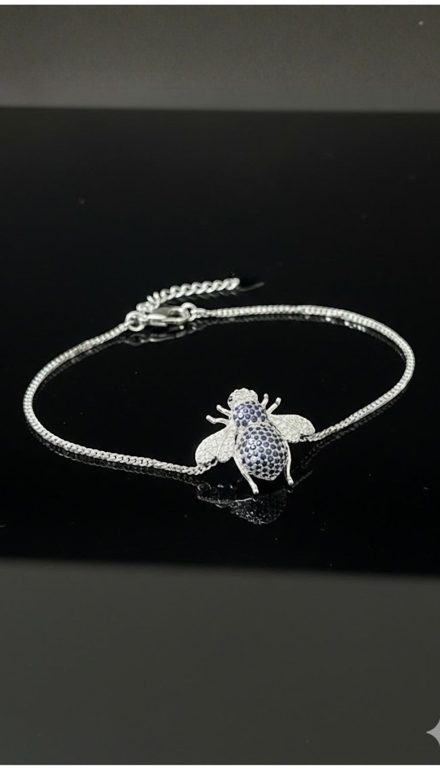 WRAPGAME INDIA silver chain bracelet with a bee charm encrusted with blue and white CZ stones.