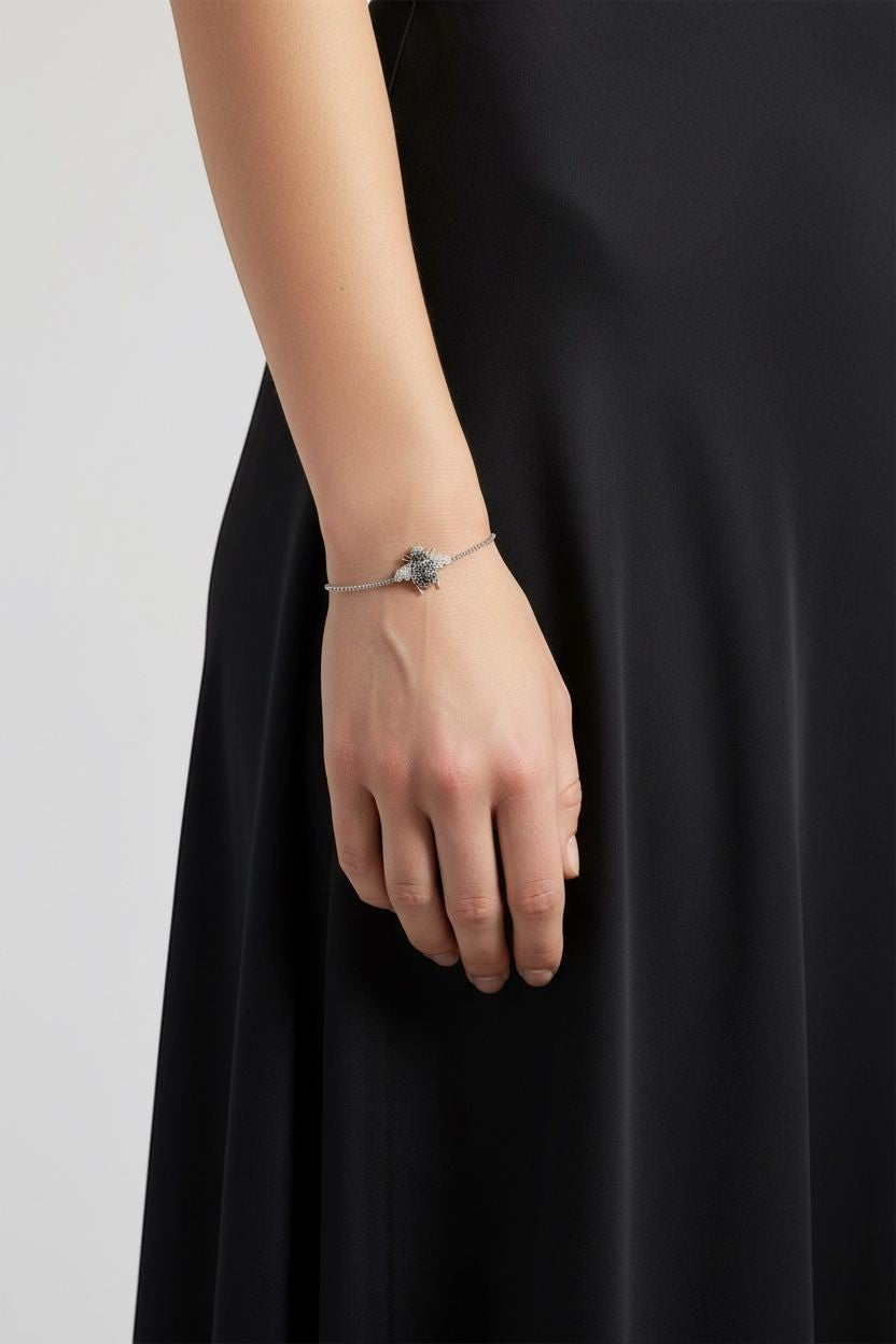 WRAPGAME INDIA silver chain bracelet with a bee charm encrusted with black and clear CZ stones.
