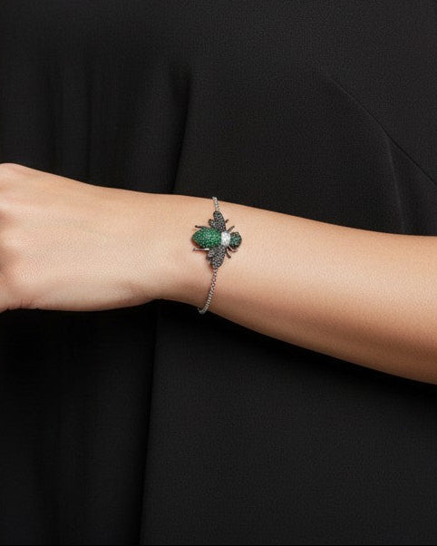 WRAPGAME INDIA Bling Bee Bracelet with green and black CZ stones on a silver chain.