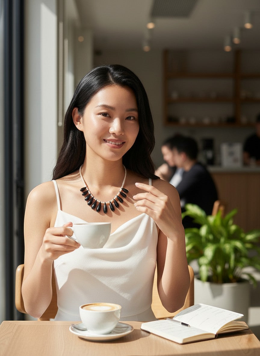 WRAPGAME INDIA Pearl Drop Chain necklace with black onyx and cultured pearls, worn by a woman in a white dress.